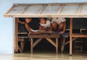 Philippines: Toddlers looking on in a partially submerged house in San Pedro, Laguna